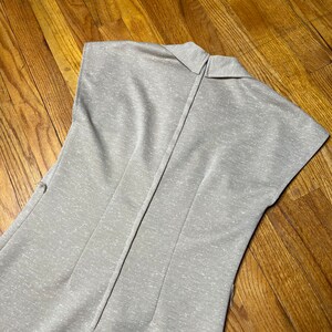 May include: A light gray sleeveless dress with a collared neckline and a zipper down the back.