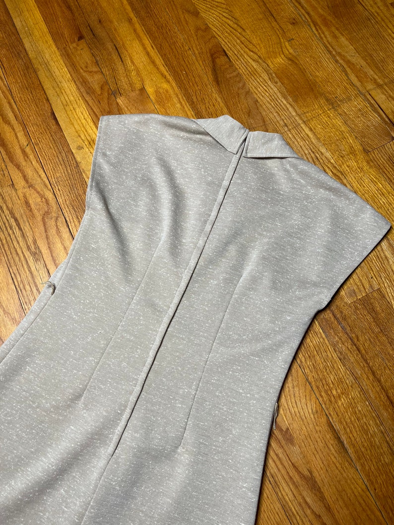 May include: A light gray sleeveless dress with a collared neckline and a zipper down the back.