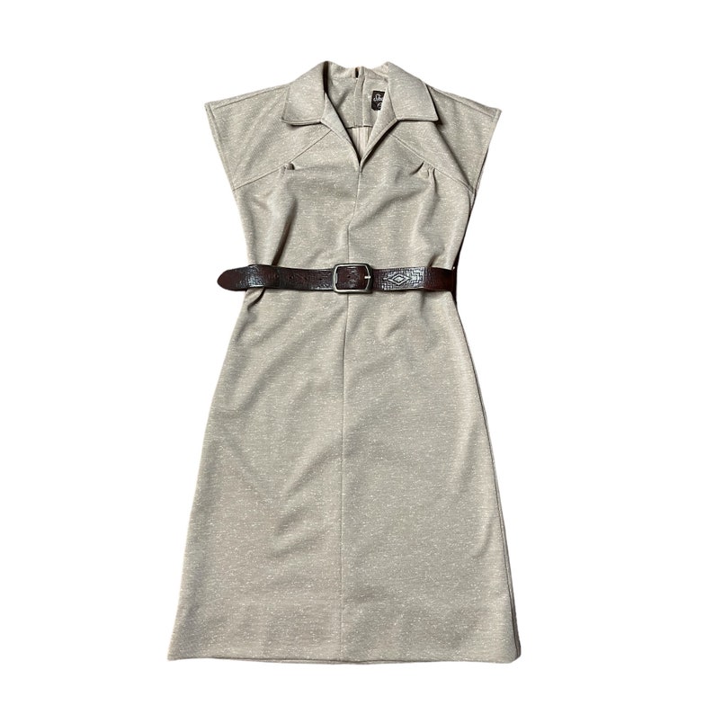 May include: A beige sleeveless dress with a collared neckline and a brown leather belt.