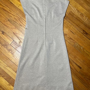 May include: A sleeveless, light gray dress with a collared neckline and a zipper down the back.