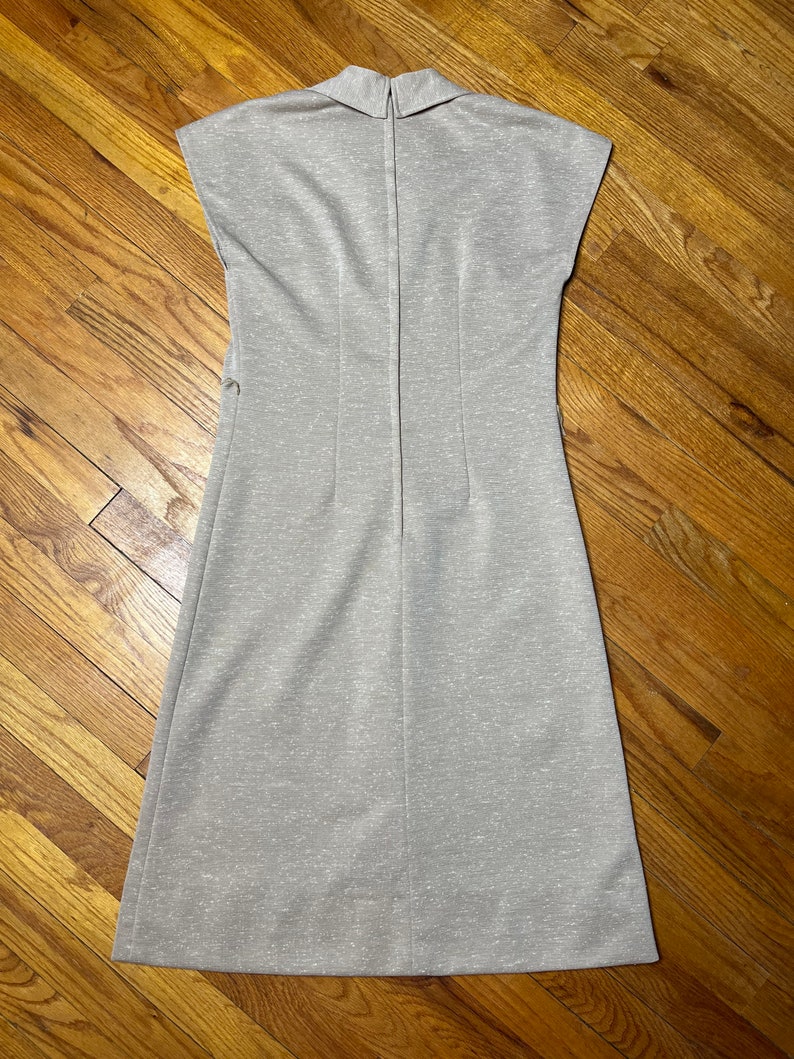 May include: A sleeveless, light gray dress with a collared neckline and a zipper down the back.
