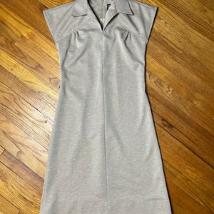 May include: A light gray sleeveless dress with a collared neckline and a slightly fitted silhouette.