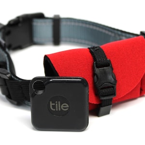 May include: A black Tile tracker attached to a red neoprene holder on a black and gray dog collar. The Tile tracker has the word "tile" printed on it.