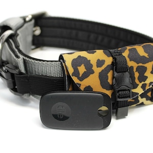 May include: A gray and black dog collar with a leopard print pouch attached. The pouch has a black strap with a buckle and a black Tile tracker is attached to the collar.