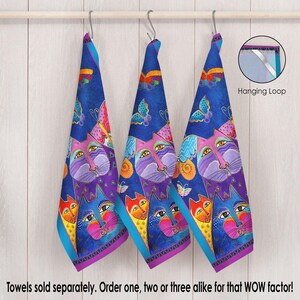 May include: Three blue kitchen towels with a colorful cat and butterfly design. The towels have a purple, yellow, and turquoise border. The text "Towels sold separately. Order one, two or three alike for that WOW factor!" is at the bottom of the image.