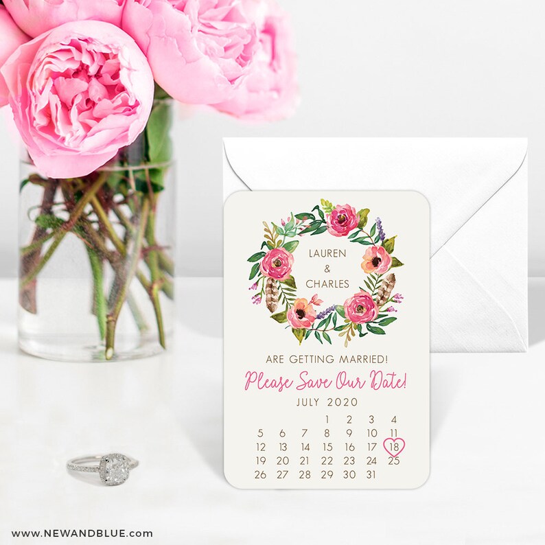 K&ouml;nnte beinhalten: Save-the-Date-Karte mit einem floralen Kranzdesign. Die Karte zeigt die Namen Lauren & Charles und das Datum 18. Juli 2020.