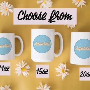May include: White ceramic mugs with the word "Aquarius" in gold script inside a light blue circle. The mugs are available in 11oz, 15oz, and 20oz sizes. The phrase "Choose From" is written above the mugs. The background is yellow with white flowers.