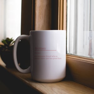11oz white mug with a customizable definition design in pink. Add a name and the definition for that person.