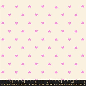 May include: Cream-colored fabric with a repeating pattern of small, pink hearts. The hearts are evenly spaced across the surface. The text "RUBY STAR SOCIETY" is printed at the bottom.