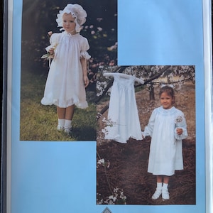 May include: A pattern cover featuring a lacy bishop dress, bonnet, and slip. The cover includes images of children wearing the white dress and bonnet. The text on the cover reads "Lacy Bishop, Bonnet & Slip" and lists sizes.