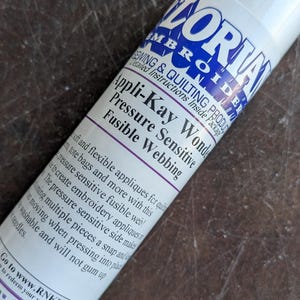 May include: A white ceramic mug with a black handle and the text "But First, Coffee" in a black, handwritten-style font. The mug is on a white surface.