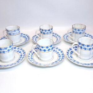 May include: Set of six white porcelain espresso cups and saucers with blue and gold floral patterns.