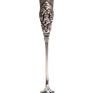 May include: Silver sugar tongs with an ornate design featuring a cherub figure and floral motifs. The tongs have a star-shaped tip.