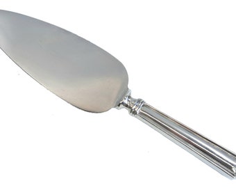 May include: A silver cake server with a long, slender handle and a rounded blade. The handle has a decorative design at the end.