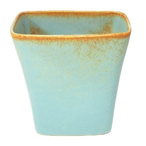 May include: A light blue ceramic planter with a brown rim. The planter has a textured, speckled finish.
