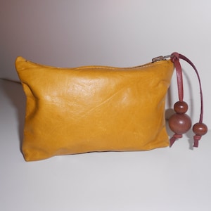 Small leather handcrafted purse with wooden bead pull