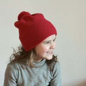 Kids simple knitted hat with pompon in alpaca blend yarn, many colors available. All sizes from infant up to adult.