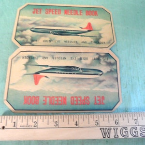 May include: Two vintage needle books with a jet plane design. The books are titled "Jet Speed Needle Book" and feature the text "115 Best Gold Eye Needles and Threader".