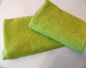 May include: Two pieces of green textured fabric. The fabric has a subtle pattern and is folded in half.