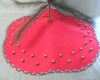 May include: Red felt Christmas tree skirt with a green and gold braided trim and silver jingle bells.