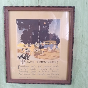 Könnte beinhalten: Gerahmter Vintage-Druck mit dem Titel "Hat's Friendship!" mit einer Illustration von frühen Automobilen und Menschen. Der Druck hat einen Sepia-Ton mit Text darunter, einschließlich eines Zitats über Freundschaft. Der Rahmen ist braun mit einem dekorativen Rand.