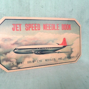 May include: Vintage cardboard needle book with a red and white airplane flying through clouds. The text on the book reads "Jet Speed Needle Book 115 Best Gold Eye Needles and Threader".