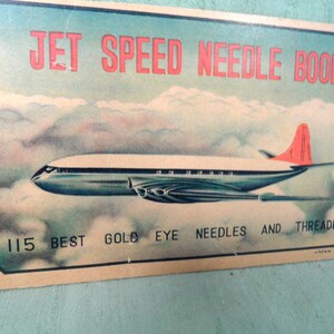 May include: Vintage packaging for a needle book featuring a blue and silver airplane flying through clouds. The text reads "Jet Speed Needle Book 115 Best Gold Eye Needles and Threader Japan".