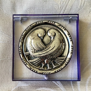 Clear lucite powder compact with a central design of silver doves