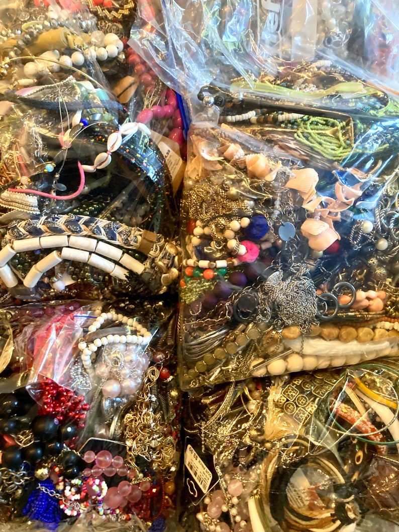Peut inclure: Une collection de bijoux color&eacute;s et assortis, comprenant des colliers, des bracelets, des boucles d'oreilles et des breloques, est organis&eacute;e dans des sacs en plastique transparents. Les bijoux sont faits de divers mat&eacute;riaux, tels que des perles, du m&eacute;tal et des pierres.
