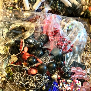 Peut inclure: Un grand sac en plastique rempli d'une vari&eacute;t&eacute; de bijoux color&eacute;s, y compris des perles, des cha&icirc;nes et des pendentifs. Les bijoux sont un m&eacute;lange de diff&eacute;rents mat&eacute;riaux, notamment du m&eacute;tal, du plastique et du verre.