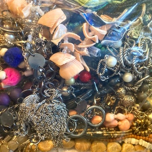 Peut inclure: Un sac en plastique rempli d'une vari&eacute;t&eacute; de bijoux, y compris des colliers, des bracelets, des boucles d'oreilles et des perles. Les bijoux sont faits de diff&eacute;rents mat&eacute;riaux, notamment du m&eacute;tal, du plastique et du bois. Le sac est rempli de diff&eacute;rentes couleurs, notamment l'or, l'argent, le noir, le blanc, le bleu, le vert et le rouge.