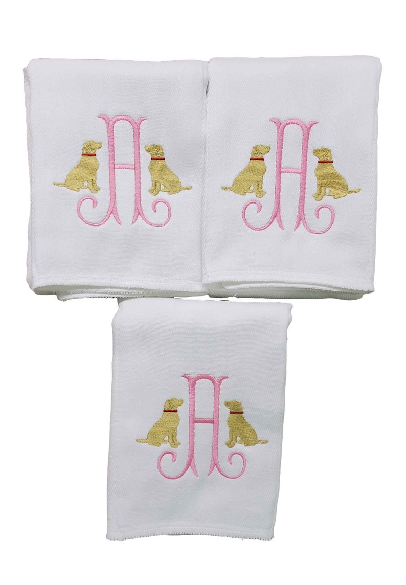 Baby girl burp cloth with a pink initial surrounding on either side with embroidered yellow lab dogs.