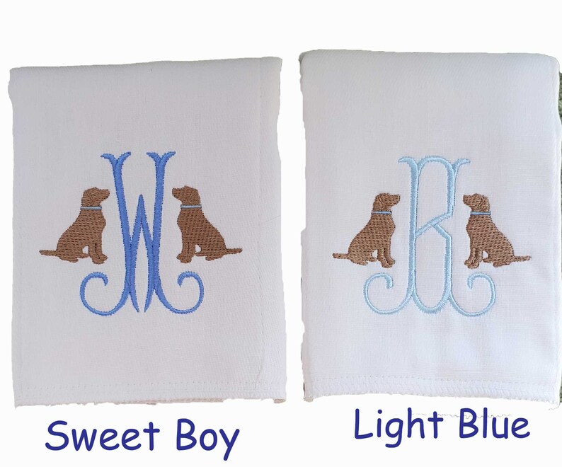 Cotton diaper burp cloth embroidered with a single initials framed with two dogs. Colors can be customized for a baby boy or girl. Pictures show the difference in blue initial colors.