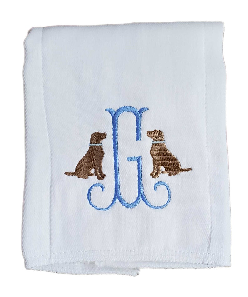 Cotton diaper burp cloth embroidered with a single initials framed with two dogs. Colors can be customized for a baby boy or girl.