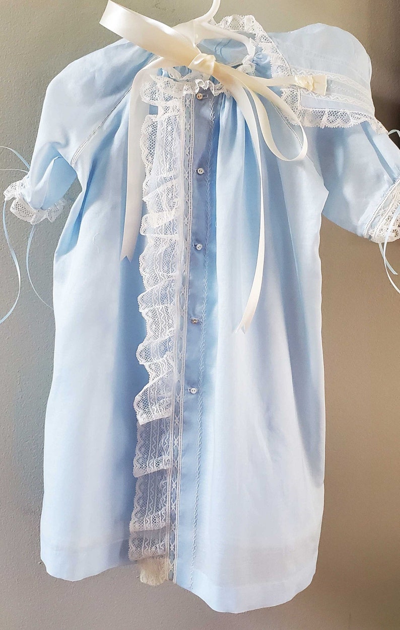 Blue Swiss batiste lace front ruffle heirloom baby gown and cap. Features French Valenciennes ivory lace, ivory hand embroidery, satin ribbon, and mother of pearl buttons.