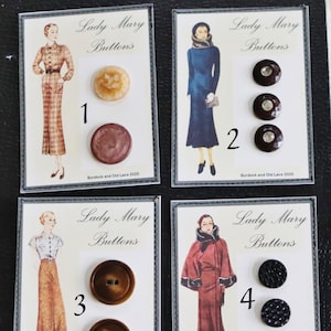 May include: Four cards of Lady Mary Buttons. Each card features a vintage illustration and buttons. The cards display various button styles, including brown, clear, and black buttons with different textures and designs. The text "Lady Mary Buttons" is visible.