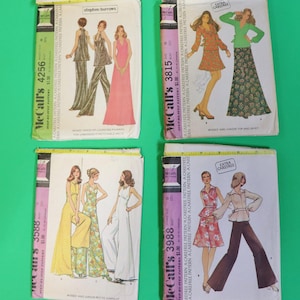 May include: Four vintage McCall's sewing patterns featuring illustrations of 1970s fashion designs. The patterns showcase dresses, jumpsuits, tops, and pants in various styles. The patterns are in their original packaging with text and illustrations.