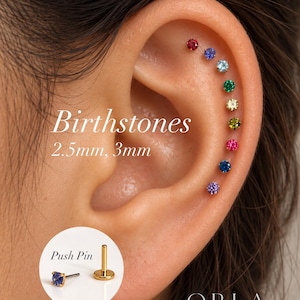 May include: A series of nine small, round, multi-colored gemstone stud earrings arranged along the outer ear cartilage. The text reads Birthstones 2.5mm, 3mm. An inset shows a gold-tone push pin earring post and a blue gemstone stud.