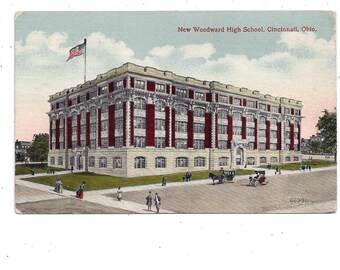 May include: A vintage postcard showing the New Woodward High School in Cincinnati, Ohio. The building is a large, brick structure with many windows and a prominent flagpole. The postcard is in good condition, with some minor wear and tear.