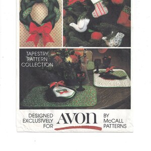 Pode incluir: Uma coleção de padrões de tapeçaria Avon vintage com uma guirlanda de Natal verde e vermelha, uma meia, um pássaro e uma mesa com jogos americanos e guardanapos. O padrão foi projetado exclusivamente para Avon por McCall Patterns.