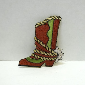 May include: Embroidered iron-on patch of a red cowboy boot with a green shaft, gold rope detail, and a white spur.