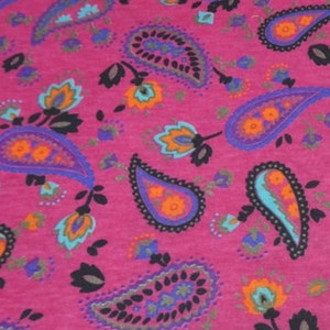 May include: Pink fabric with a paisley pattern in shades of blue, orange, and black.