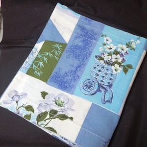 May include: A blue and white patchwork fabric with a floral design. The fabric features a green bamboo design, a blue and white floral design in a blue vase, and a white floral design.