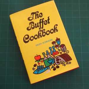 May include: A vintage cookbook titled "The Buffet Cookbook" by Helen Schrader. The cover is yellow with brown lettering and colorful illustrations of food and drink. The book has red edges.