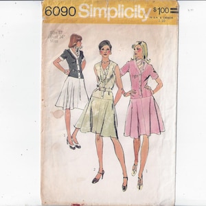 May include: Vintage Simplicity sewing pattern 6090 showing three women's outfits. The illustration depicts a white skirt with a black and white top, a light green dress with a belt, and a pink skirt suit. The pattern is size 12, bust 86 cm.