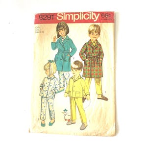 Op de afbeelding: Een Simplicity 8291 naaipatroon-envelop voor kindermaten 2, borstomvang 21. De illustratie toont vier kinderen in pyjama's en jassen met blauwgroene, geruite, gele en bloemmotieven. Een klein wit eendje als speelgoed staat onderaan in het midden.