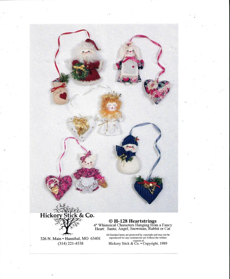May include: A set of 4 inch whimsical characters hanging from a fancy heart. The characters include Santa, an angel, a snowman, a rabbit, and a cat. The characters are made of fabric and are decorated with various details. The hearts are made of fabric and are decorated with different patterns. The characters are all hanging from a ribbon. The image includes the text "H-128 Heartstrings" and "Hickory Stick & Co. Copyright, 1989".