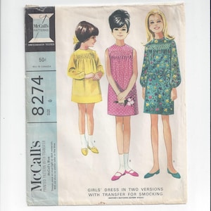 May include: Vintage McCall's sewing pattern for a girl's dress in two versions. The pattern includes a transfer for smocking. The pattern number is 8274, size 6. The pattern is printed on a white background with a blue border.