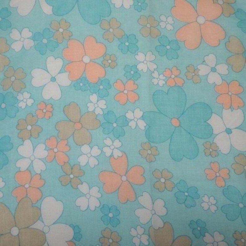 May include: A floral pattern featuring large and small flowers in shades of peach, white, brown, and teal on a light blue background. The flowers have a retro, stylized design, creating a vintage aesthetic.