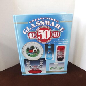 May include: A blue book cover with the title "Collectible Glassware from the 40s 50s 60s" and a picture of a red, white, and blue plate with a red barn and a bridge, a blue glass decanter, a red glass candle holder, and a red and white glass jar.